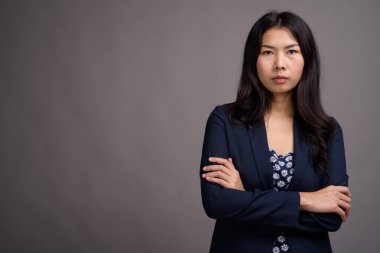 Asyalı kadın mavi elbisesi ve gri karşı kazak hırka giymiş