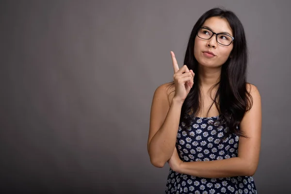 Ázsiai nő visel szemüveg ellen szürke háttér — Stock Fotó