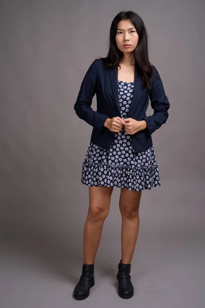 Mujer asiática vistiendo vestido azul y suéter de cárdigan contra gris —  Fotos de Stock