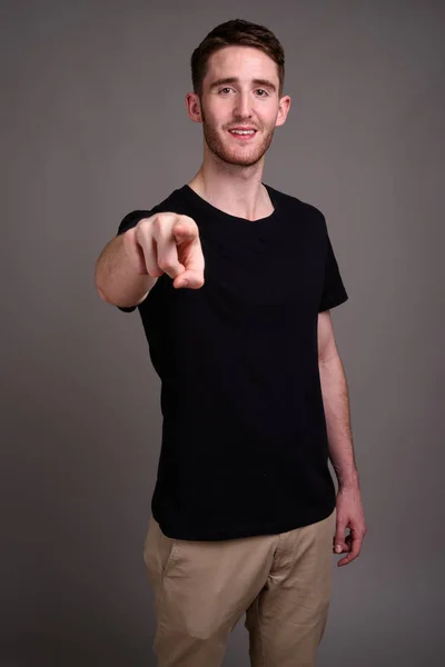 Retrato de un joven guapo sobre fondo gris — Foto de Stock