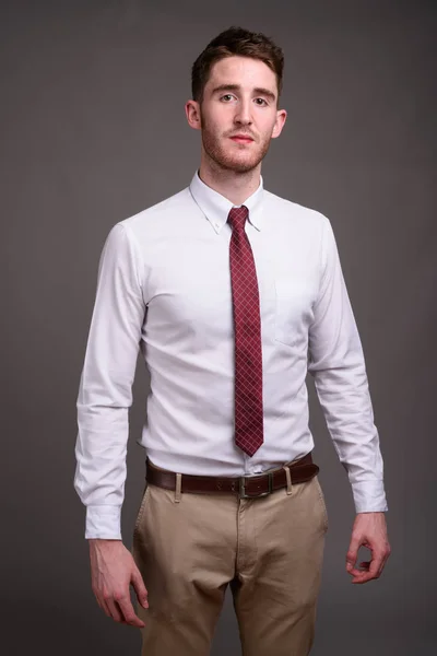 Retrato de joven hombre de negocios guapo sobre fondo gris — Foto de Stock