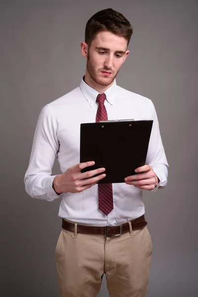 Retrato de joven hombre de negocios guapo sobre fondo gris — Foto de Stock