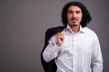 Gri arka planda bıyıklı yakışıklı bir iş adamı.