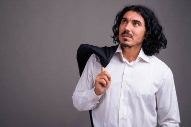 Gri arka planda bıyıklı yakışıklı bir iş adamı.