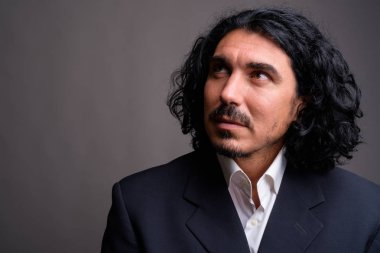 Bıyıklı gri bac karşı takım elbise giymiş yakışıklı işadamı