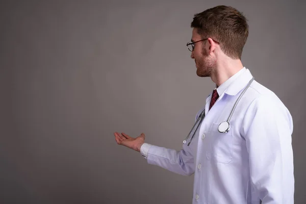 年轻英俊的男医生戴眼镜对灰色的背板 — 图库照片
