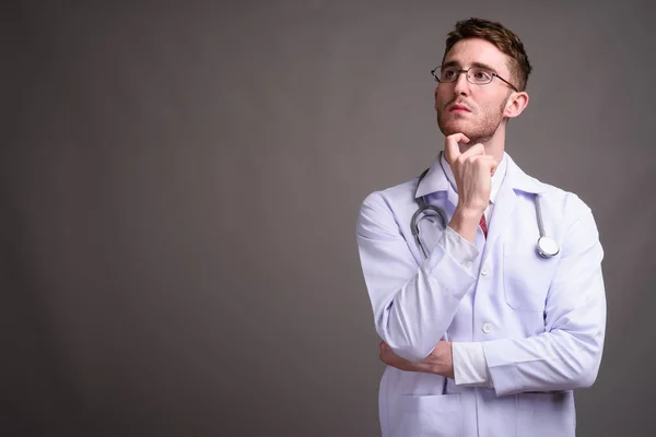 Genç yakışıklı Doktor gri backgr karşı gözlük takan adam — Stok fotoğraf