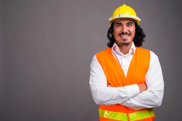 Hombre guapo trabajador de la construcción con bigote contra la espalda gris — Foto de Stock