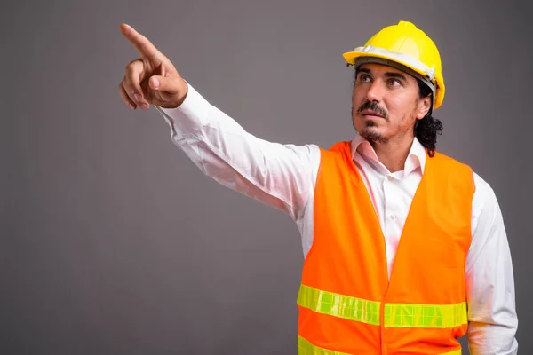 Hombre guapo trabajador de la construcción con bigote contra la espalda gris —  Fotos de Stock