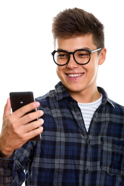 Студійний знімок молодого щасливого чоловіка, який посміхається під час використання мобільного телефону — стокове фото