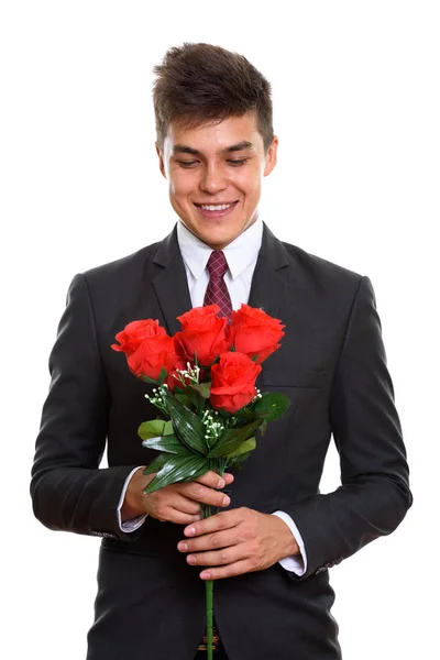 Nuori onnellinen liikemies hymyilee pitäen ja katsoen punaista — kuvapankkivalokuva