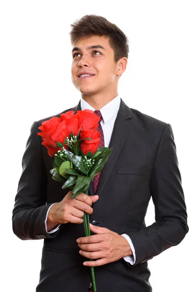 Pengusaha muda yang penuh perhatian tersenyum sambil memegang ros merah — Stok Foto