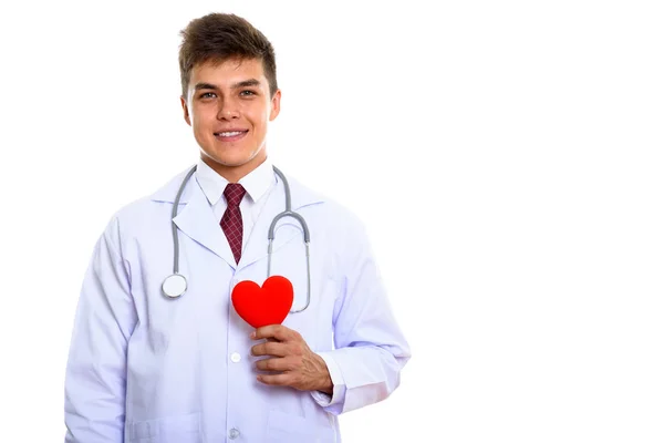 Студійний знімок молодого щасливого лікаря, який посміхається, тримаючи червоний — стокове фото