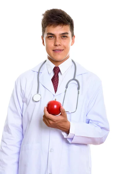 Studio shot of young handsome man doctor holding red apple — Stock Photo, Image