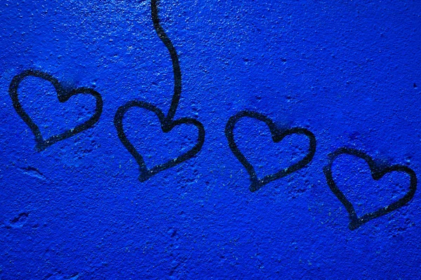 Blue painted wall background with heart signs — Stock Photo, Image