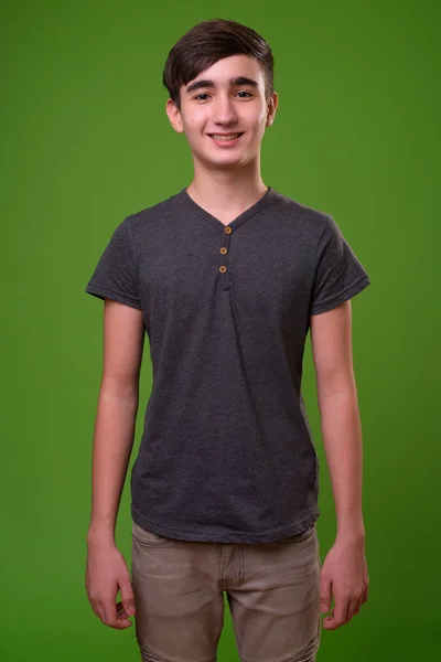 Fiatal jóképű iráni tizenéves fiú zöld háttér — Stock Fotó