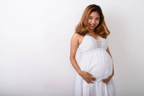 Strzał studio młodych szczęśliwy Asian kobieta w ciąży uśmiechający się przeciwko — Zdjęcie stockowe
