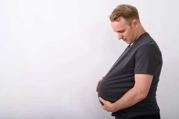 Mężczyzna, trzymając jego żołądek, jak on będzie w ciąży i spodziewa się dziecka — Zdjęcie stockowe