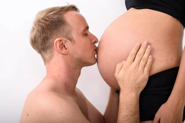 복 부와 그의 임신한 아내의 위장 키스 하는 남자 — 스톡 사진