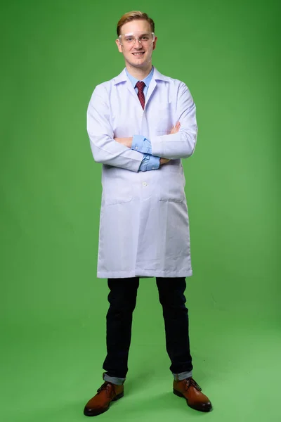 Jovem médico homem bonito com cabelo loiro vestindo gla protetora — Fotografia de Stock