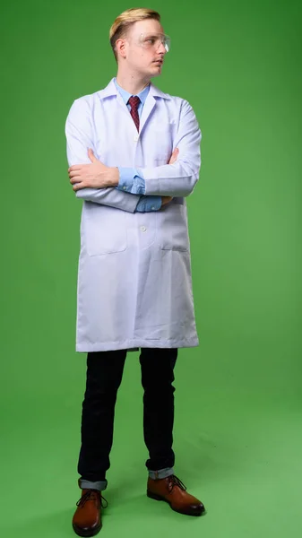 Joven hombre guapo doctor con pelo rubio usando gla protectora — Foto de Stock