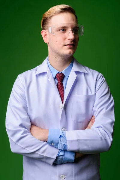 Jovem médico homem bonito com cabelo loiro vestindo gla protetora — Fotografia de Stock