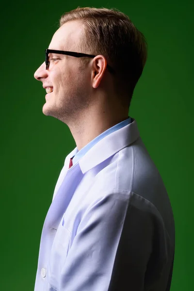 Όμορφος νεαρός γιατρός με ξανθά μαλλιά κατά πράσινο λεμονάτα — Φωτογραφία Αρχείου