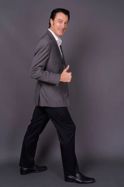 Porträt eines gut aussehenden Geschäftsmannes vor grauem Hintergrund — Stockfoto