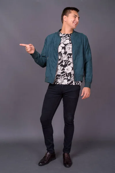 Studio shot of young handsome man against gray background — Stock Photo, Image