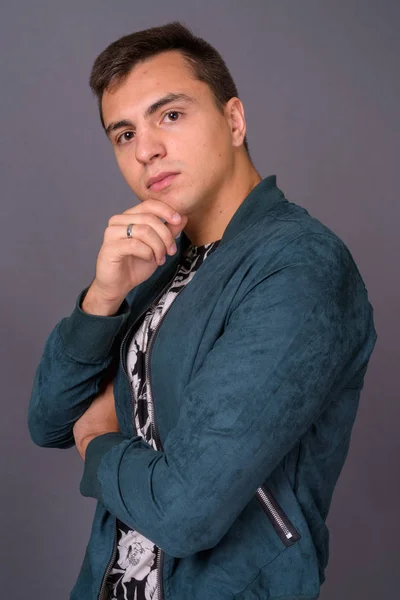 Profile view of young handsome man against gray background — Stock Photo, Image