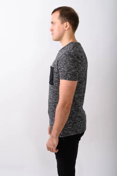 Profilo vista di giovane uomo muscoloso in piedi contro lo schienale biancogr — Foto Stock