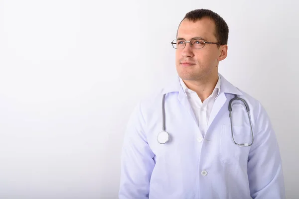 Студійний знімок молодого м'язистого лікаря, який думає під час носіння — стокове фото