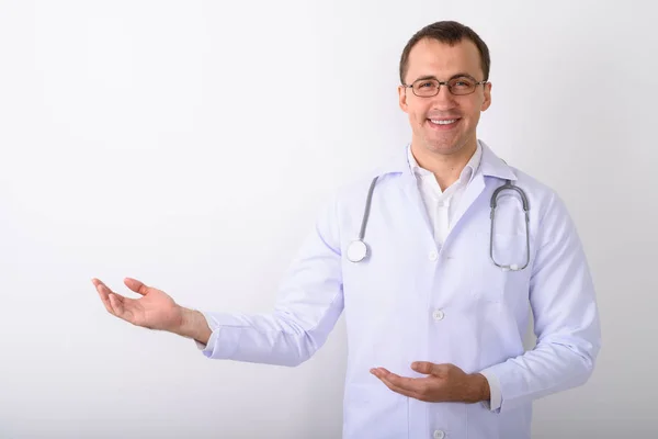 Студійний знімок молодого щасливого м'язового лікаря, який посміхається, поки ми — стокове фото