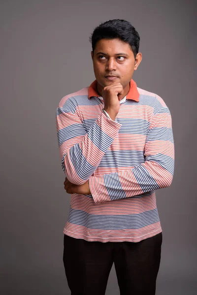 Retrato de jovem indiano contra fundo cinza — Fotografia de Stock