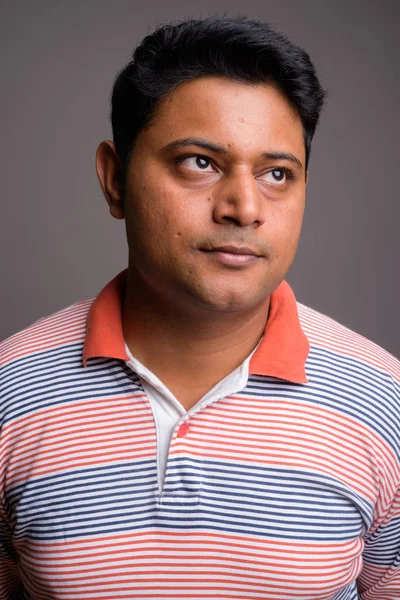Портрет молодого индийца на сером фоне — стоковое фото