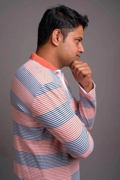 Портрет молодий індійський чоловік проти сірий фон — стокове фото