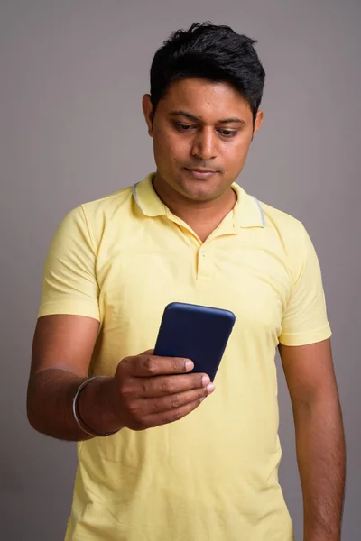 Portrait of young Indian man against gray background — Stock Photo, Image