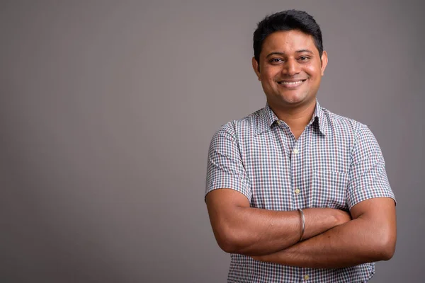 Gri arka plan karşı Genç Hintli işadamı portresi