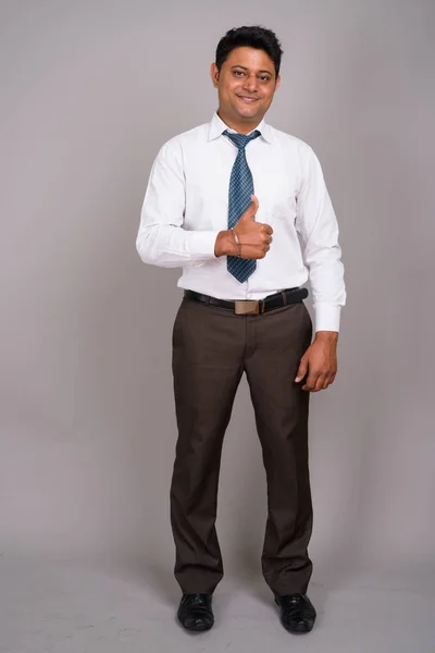 Ritratto di giovane uomo d'affari indiano su sfondo grigio — Foto Stock