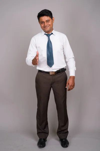 Portret młodego indyjski biznesmen szarym tle — Zdjęcie stockowe