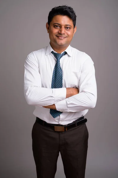 灰色の背景の若いインドのビジネスマンの肖像画 — ストック写真