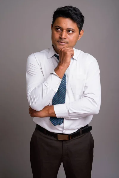 Retrato de joven empresario indio sobre fondo gris — Foto de Stock