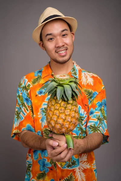 Retrato de un joven turista asiático sosteniendo piña — Foto de Stock