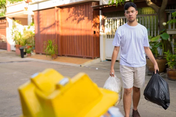 Jovem ásia homem tomando fora o lixo no casa — Fotografia de Stock