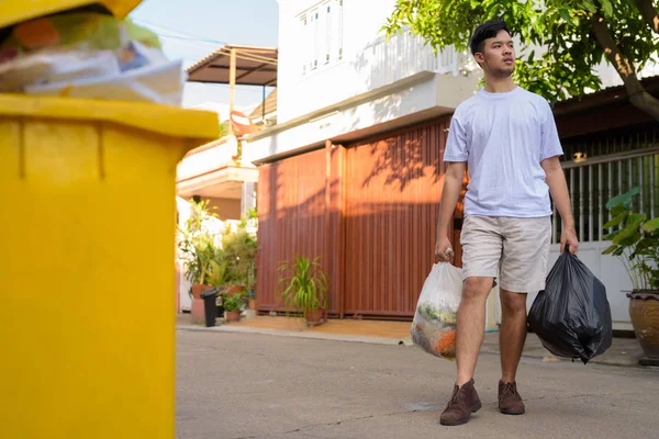 Junger Asiate räumt den Müll zu Hause aus — Stockfoto
