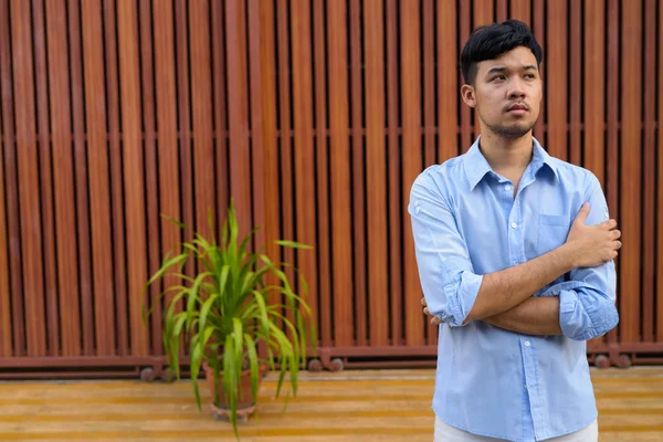 Joven hombre de negocios asiático en las calles contra outdo puerta de madera —  Fotos de Stock