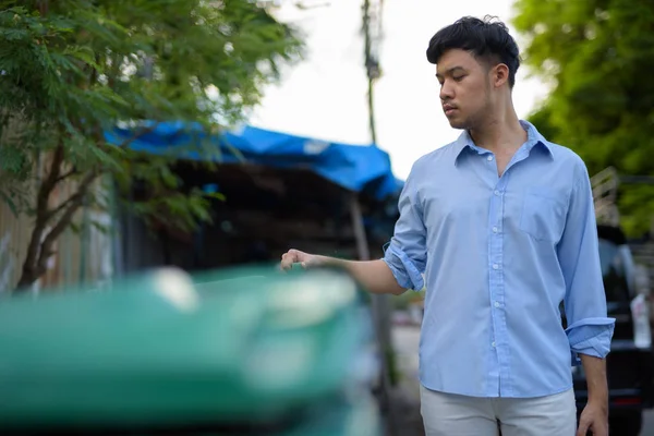 Genç Asyalı işadamı sokakları outd çöpe kontrol