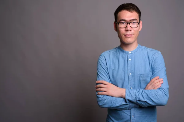 Retrato de jovem empresário asiático contra fundo cinza — Fotografia de Stock