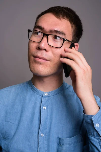 Portrait de jeune homme d'affaires asiatique sur fond gris — Photo