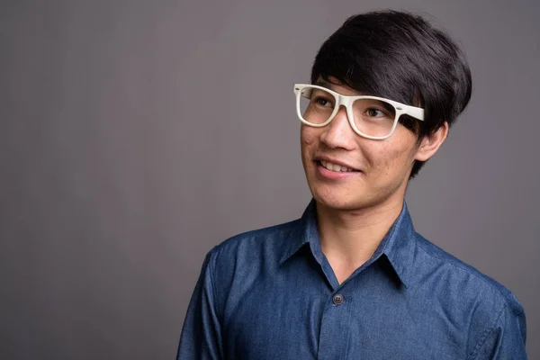 Küçük Asya adam giyen gözlük gri ba karşı akıllı arıyorum — Stok fotoğraf